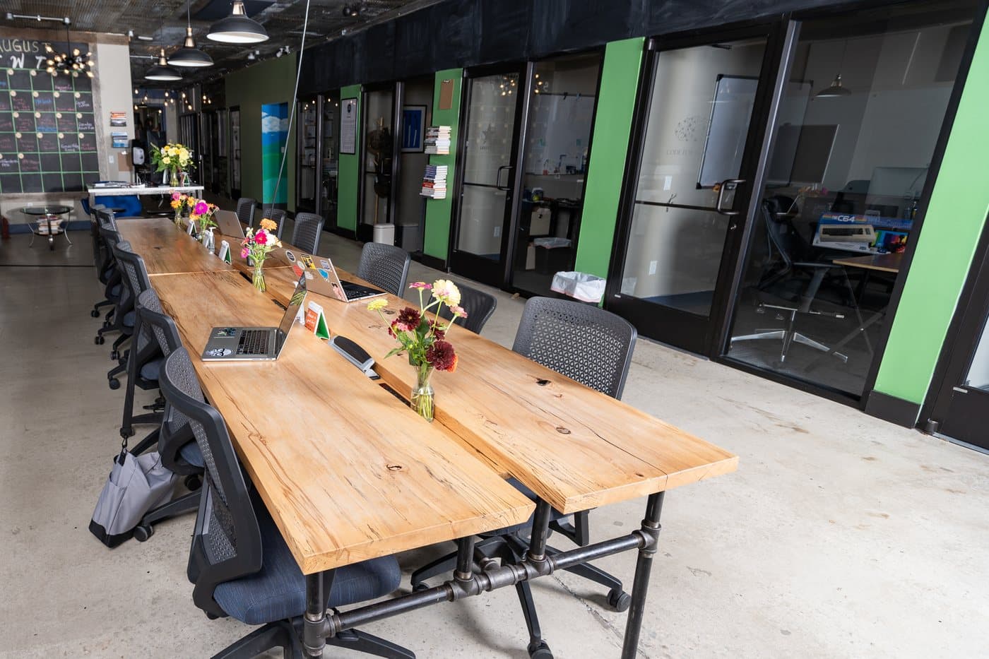 Long reclaimed-wood communal tables with office chairs