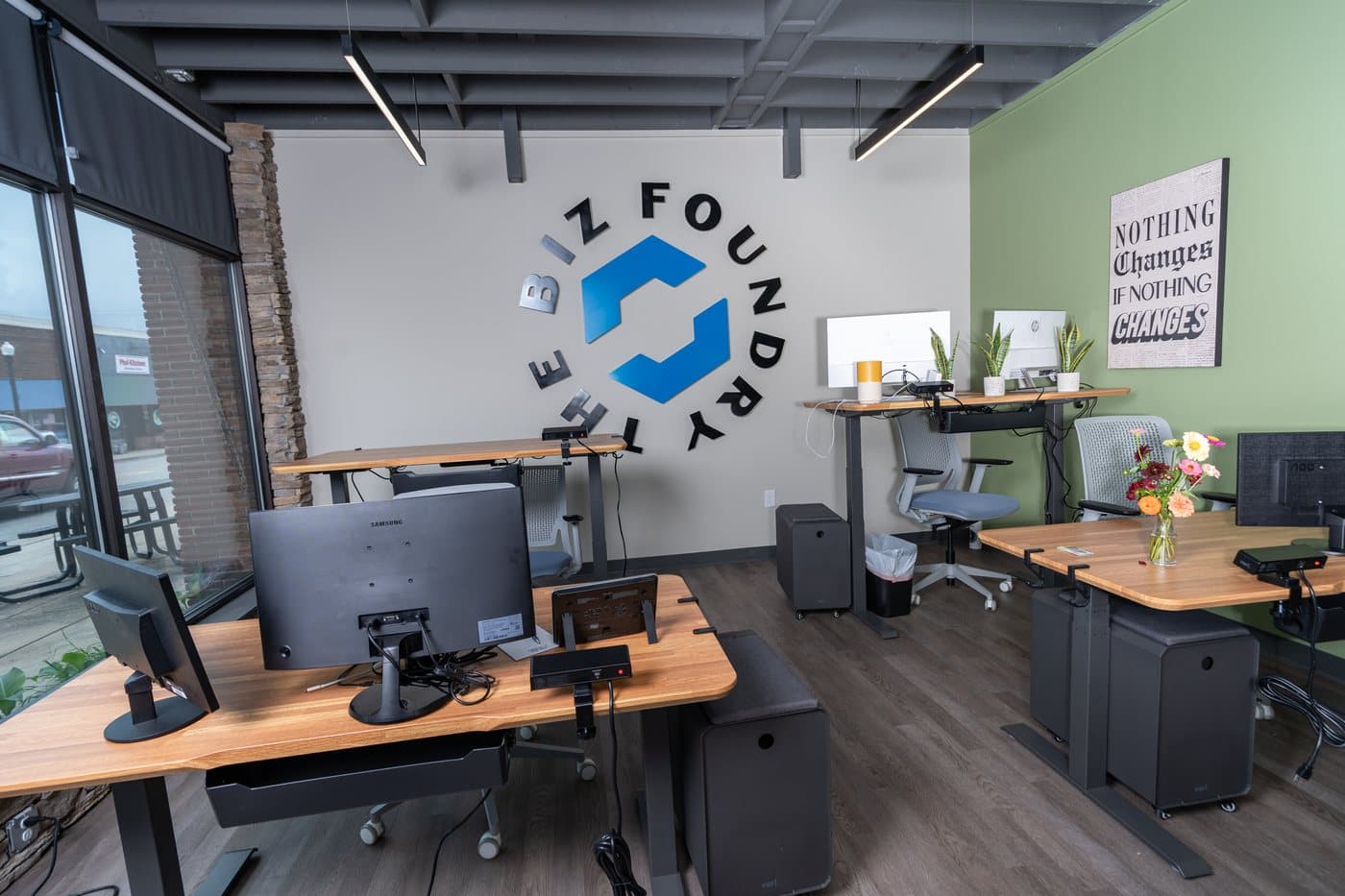 A row of dedicated standing desks with monitors and privacy barriers