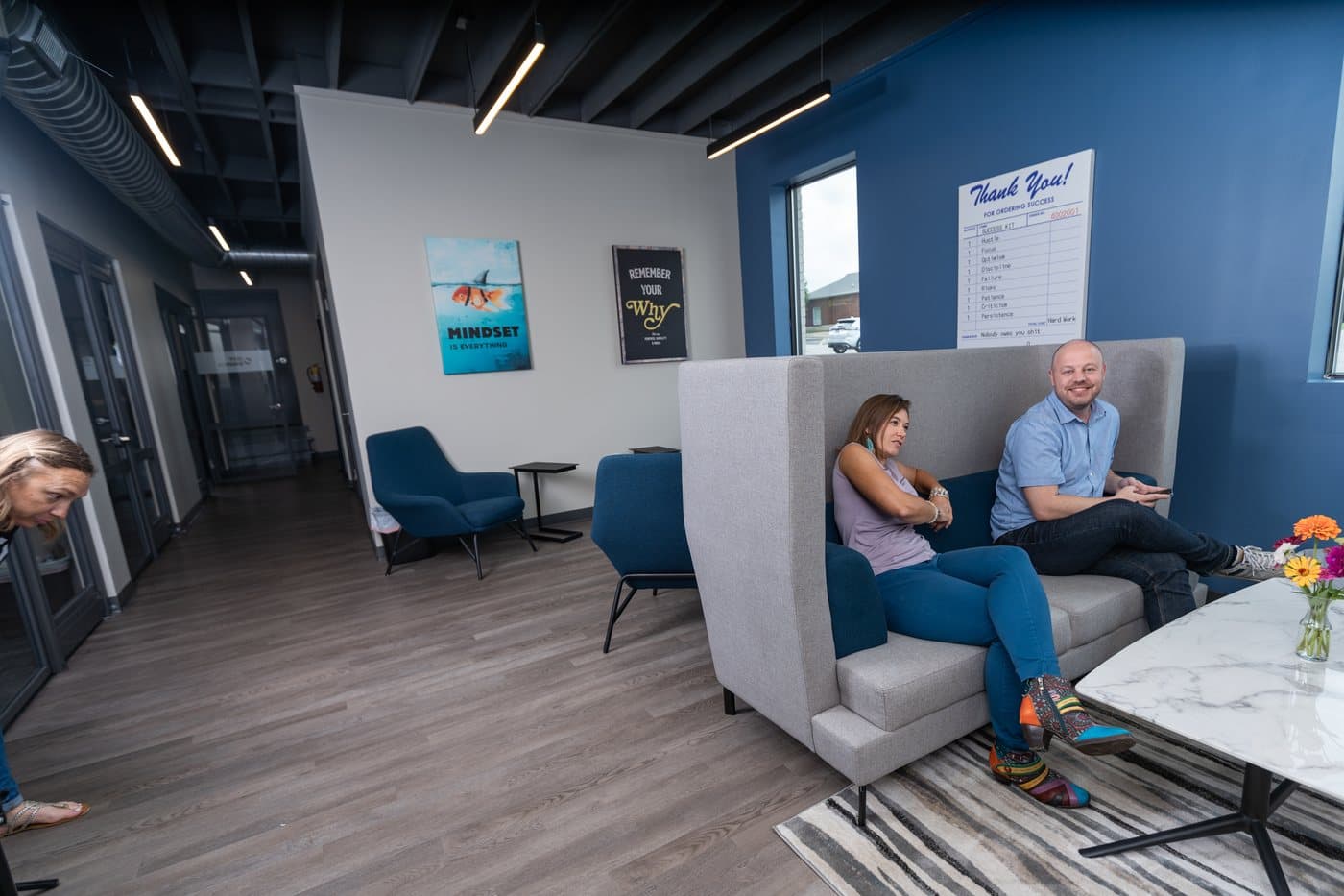 Two people talking in a high-backed lounge booth