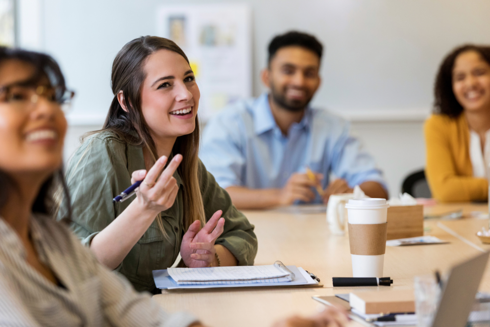 stock image of young professionals sitting at table networking and learning