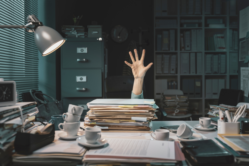 person behind overwhelming work on desk