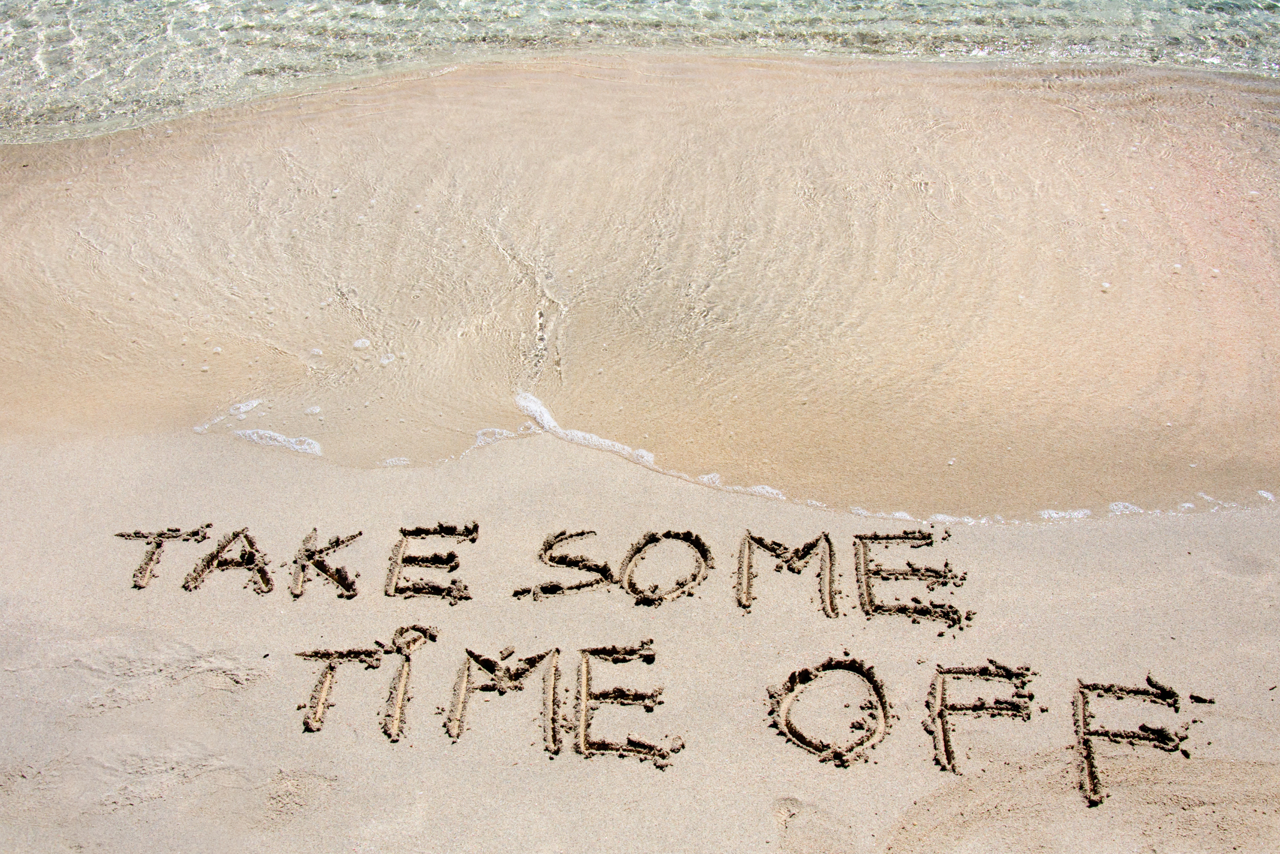 Beach shore with words take some time off write in the sand