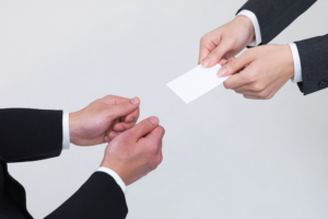 man giving business card to another man
