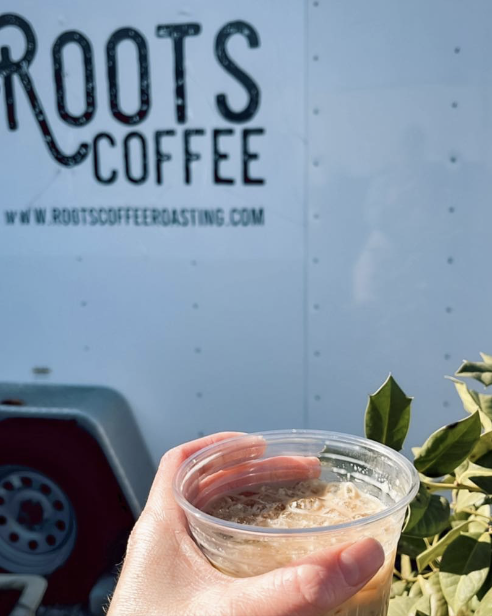 Hand holding iced coffee from Roots Coffee in Cookeville TN