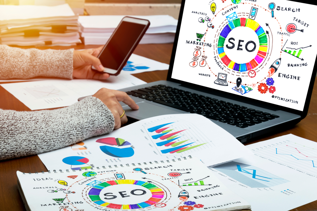 Photo of woman sitting at a desk with a laptop that says "SEO"