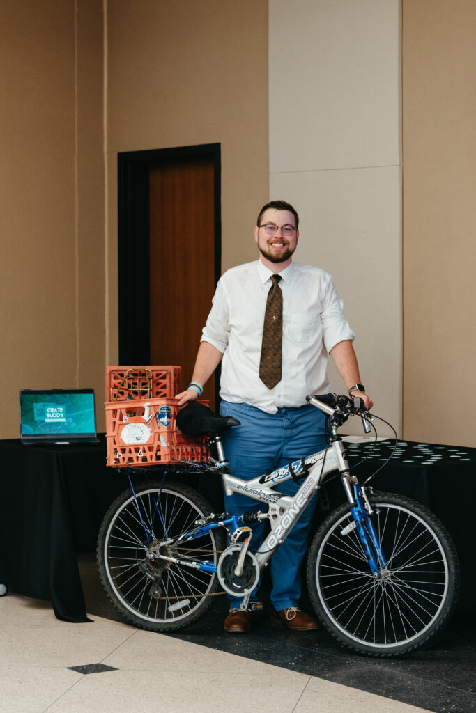 Tennessee Techs 2023 Eagleworks Winner Craet Buddy standing next to a bicycle with his product attached