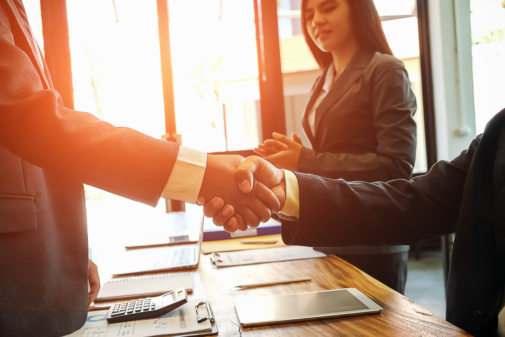 Two business people shaking hands over a sellable business.