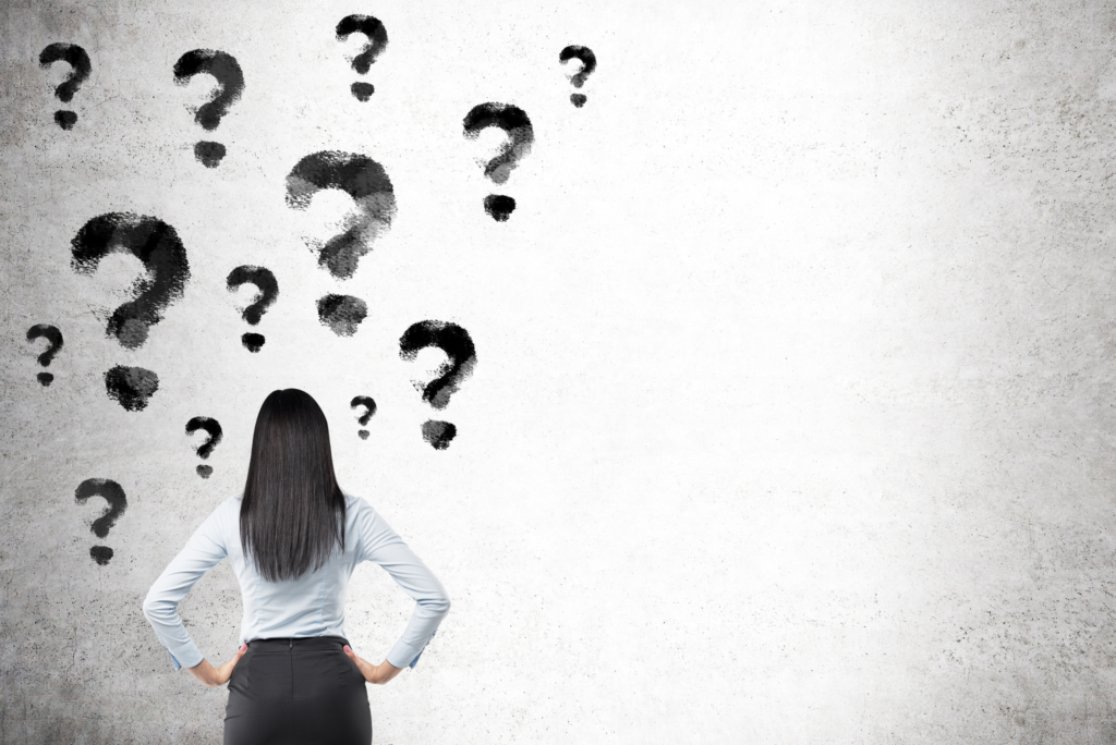 picture of back of woman looking at wall with question marks